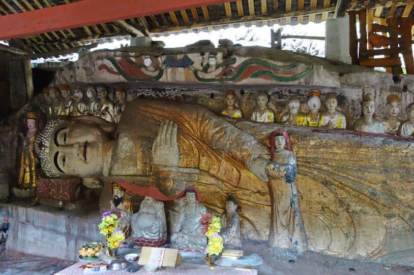 Large sheltered reclining figure with smaller painted figures at Kunfo Temple